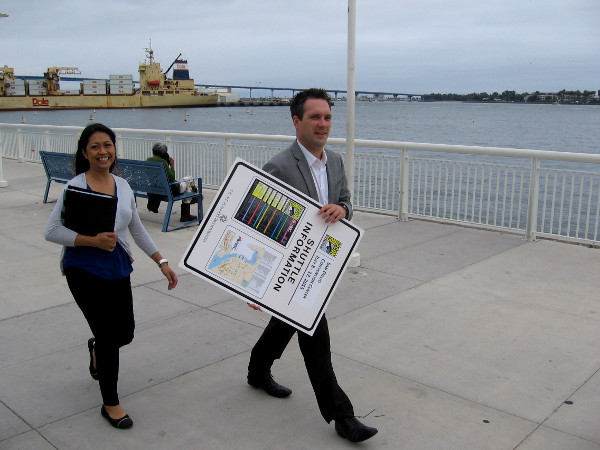 These smiling folks were heading along the bay walkway with a sign containing Comic-Con shuttle information.
