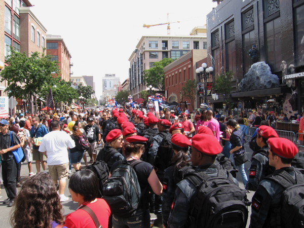 Red-bereted soldiers from Colony television show march in file up Fifth Avenue through San Diego's Gaslamp.