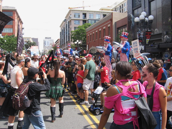 Uncle Sams on stilts with sharks through their chests add to the absurdity of the already ridiculous scene.
