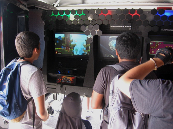 Kids check out video games at the Alienware exhibit in the Interactive Zone.