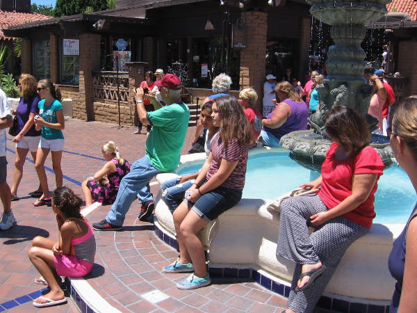 Folks relax as they listen to a small concert by a Seaport Village fountain.