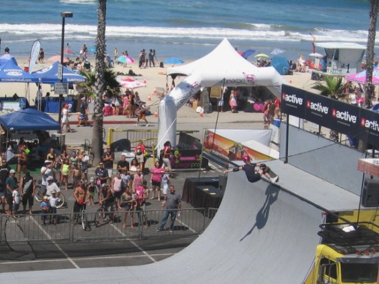People watch an athlete defy gravity on the halfpipe at 2015 Supergirl Pro!