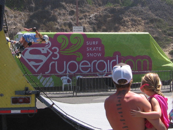 Young girl watches female skating athlete at Supergirl Pro. Perhaps what she sees will provide her with inspiration.