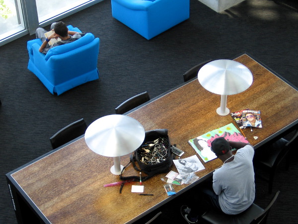 Library patron in reading room creates cool graffiti art with the aid of research materials.