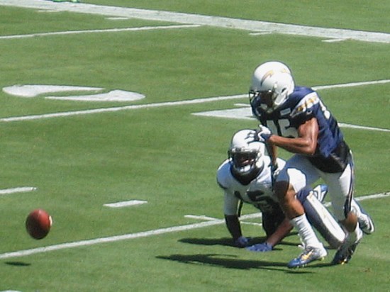 The pigskin bounces crazily on the grass as Chargers vie for possession.