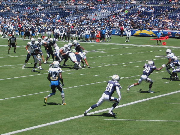 An exciting play near the end zone has players scrambling at full speed.