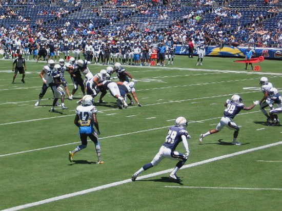 An exciting play near the end zone has players scrambling at full speed.