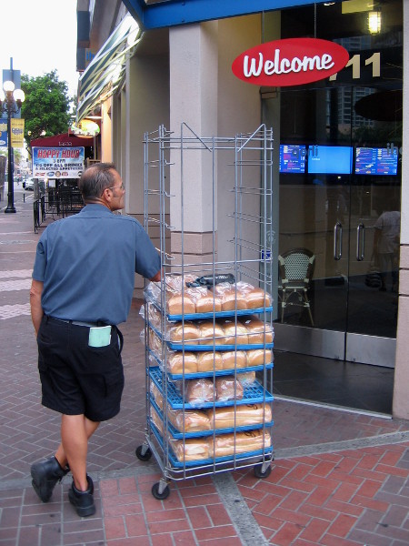 Delivery man with fresh bread awaits morning opening of restaurant in the Gaslamp Quarter.