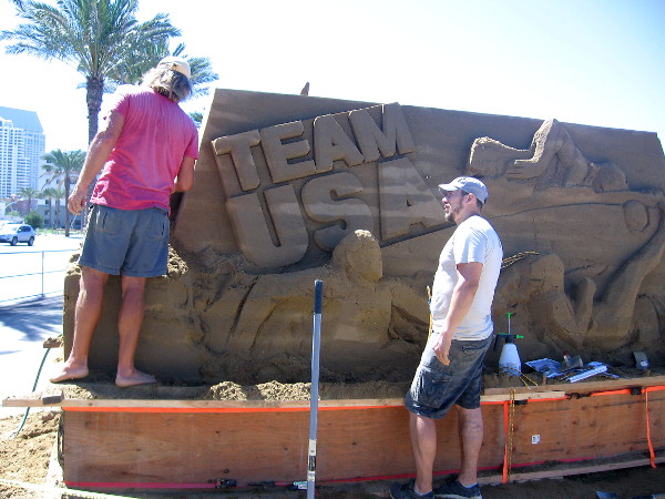 Dan Belcher from St. Louis, Missouri and Ilya Filimontsev from Moscow, Russia, work together on the big event's welcoming Team USA sand sculpture.