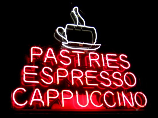 Neon words above downtown San Diego cafe door read Pastries Espresso Cappuccino.