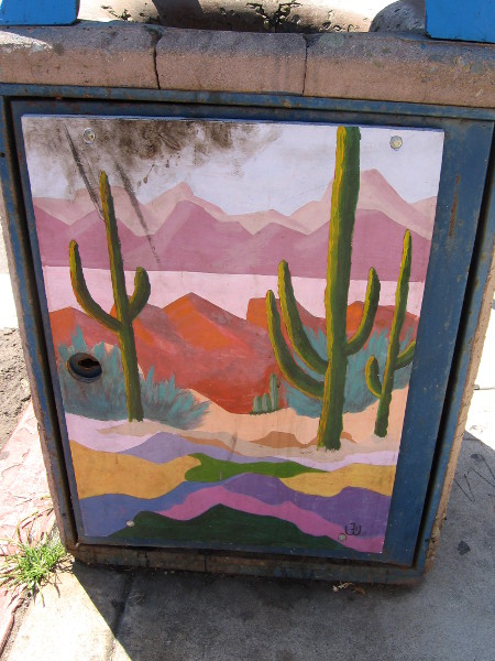 Urban art on a La Jolla trashcan shows a boldly colorful Southwestern scene, with mountains and cacti.