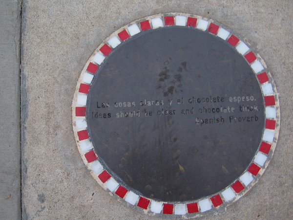 A second plaque further down the sidewalk proclaims Las cosas claras y el chocolate espeso. Ideas should be clear and chocolate thick. Spanish Proverb