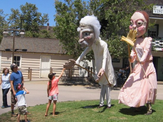 Girl greets large puppet Mark Twain and Emily Dickinson at 2015 TwainFest in Old Town San Diego State Historic Park!
