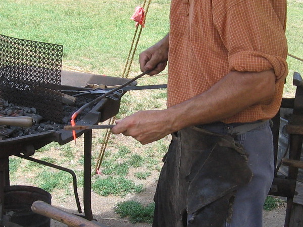 This sliver of red hot iron with some hammering will be turned into a nail with a flat head, ready to be used for 19th century construction.