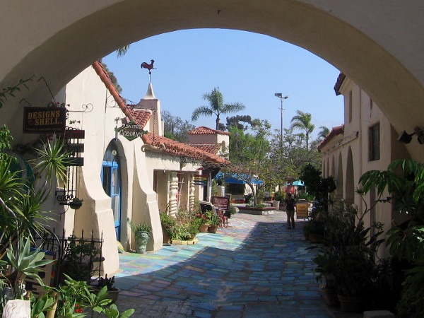 A peek through an arch into Spanish Village from the small north parking lot.