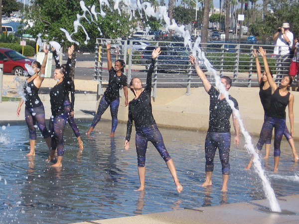 Dancers in the fountain at San Diego's Waterfront Park reach skyward during the Trolley Dances.