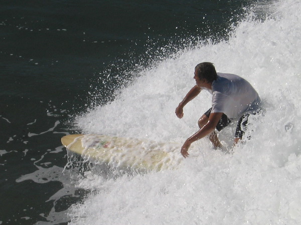 Photo of guy surfing near the pilings of the awesome Ocean Beach Municipal Pier.