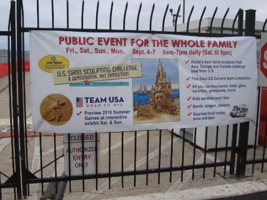 Banner on fence at B Street Pier near Cruise Ship Terminal promotes the 2015 U.S. Sand Sculpting Challenge and Dimensional Art Exposition in San Diego.