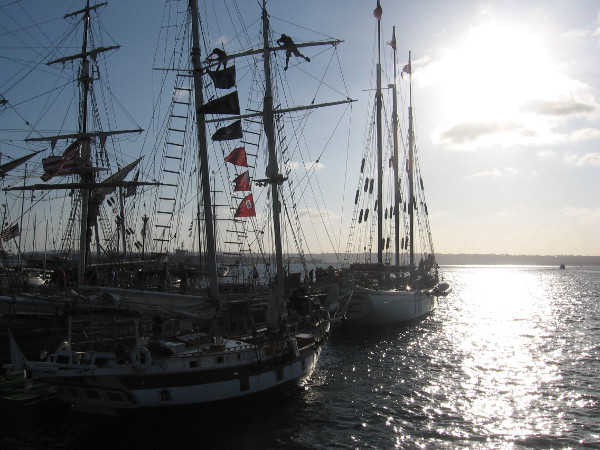 Falling sun behind evening clouds and picturesque dark masts on San Diego Bay at the Festival of Sail.
