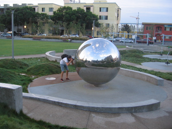 Photographer records cool reflections in one of the large stainless steel spheres in Fault Line Park.