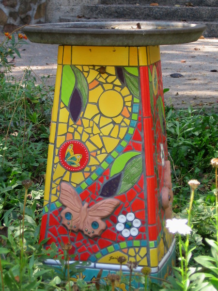 An artistic bird bath in the garden depicts leaves, flowers and butterflies, naturally!