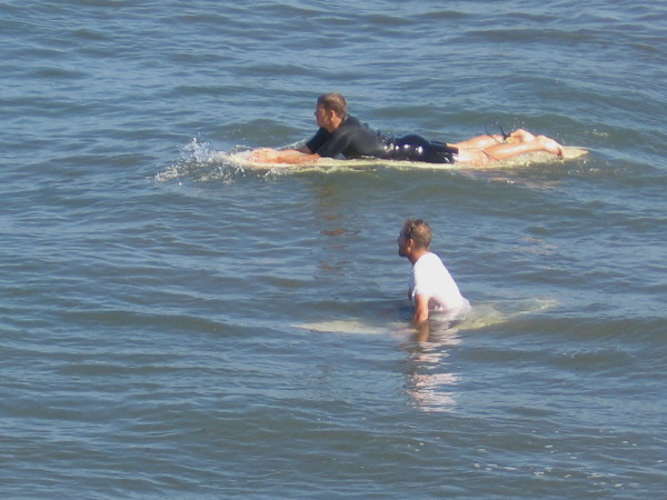 Two surfers wait for a good wave.