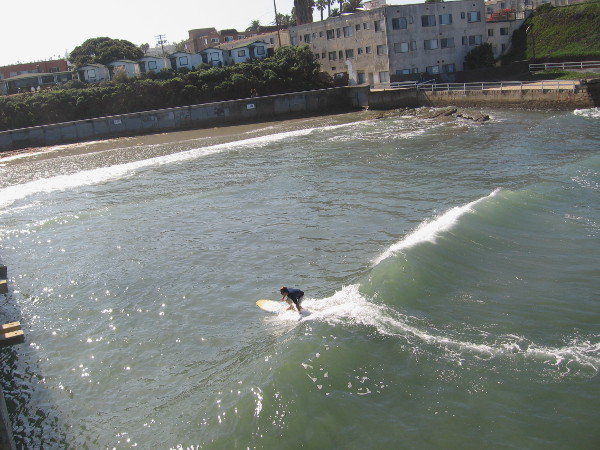 This guy caught one, and is riding it in toward the shore, just south of the pier. That low wall you see on the right belonged to the long-defunct saltwater Plunge.