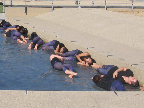 Dancers rehearse the very beginning of the performance, which involves rolling out through the shallow fountain.