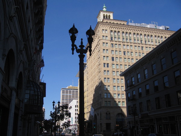 Photo of the San Diego Trust and Savings Bank Building taken from one block east on Broadway. The 14-story structure is topped with a two-story penthouse and cupola.