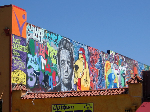 This is the best photo I could get of a really long colorful mural along a rooftop. I see James Dean and Muttley!