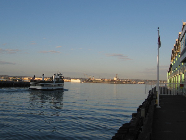 Early morning light at San Diego's Broadway Pier. The Coronado ferry has begun another trip across the quiet, glassy water.