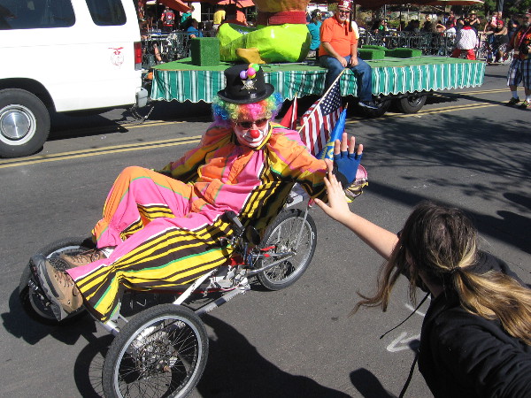 Shriner clown gives high fives to crowd during the 2015 Mother Goose Parade in El Cajon, California.