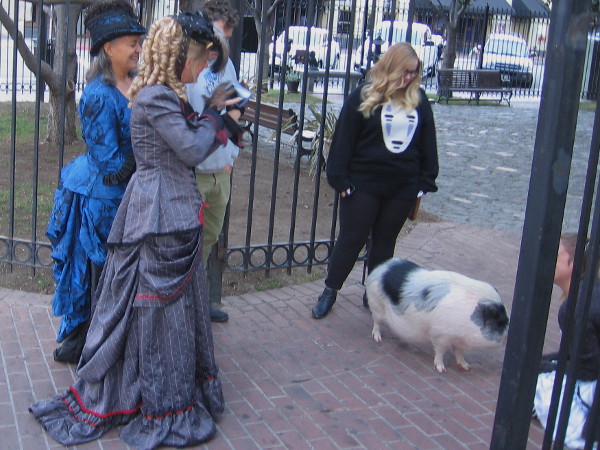 Ladies in frilly dresses linger between television shoots promoting San Diego's Fall Back Festival. The event, located near the William Heath Davis House Museum, will recreate a 1880s frontier town.