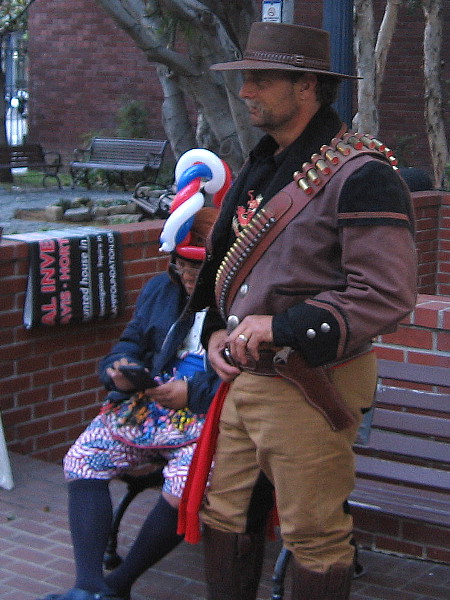 A tough Western character hangs out with a silly balloon twister guy. The bench is outside the William Heath Davis House in the Gaslamp.