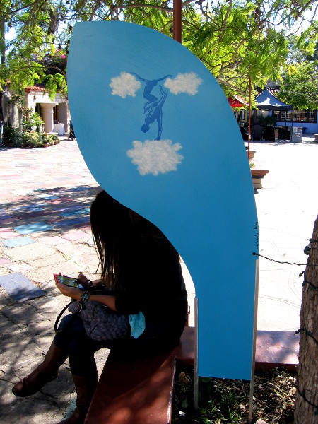 Someone sits on a planter which contains artwork representing minimalism, a literalist movement that arose during the 1960s.