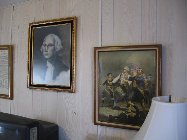 Famous portraits and memorabilia from American history cover walls and fill shelves in the House of USA Cottage.