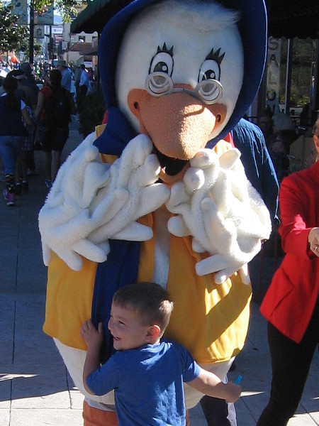 A young boy hugs Mother Goose before the parade begins.