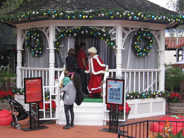 Mrs. Claus greets a child and mother at the Seaport Village's East Plaza Gazebo.