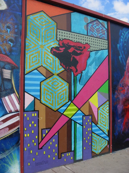 Another section of the public artwork depicts a large red rose, among buildings and interesting patterns. Created by Kreashun.