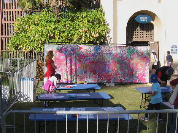 Kids by the Botanical Building paint a huge community canvas during December Nights.