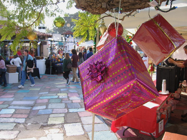 Christmas presents dangle from a tree in festive Spanish Village during December Nights.
