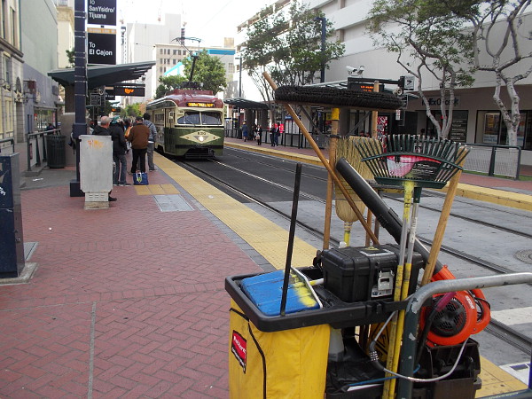 Clean and Safe equipment in the foreground, as a Silver Line vintage trolley approaches the Fifth Avenue station.