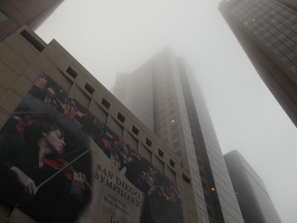 Looking up toward the unusually thick fog past a San Diego Symphony banner downtown.