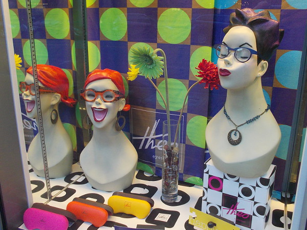 Two funny, silly mannequin heads in a shop window.