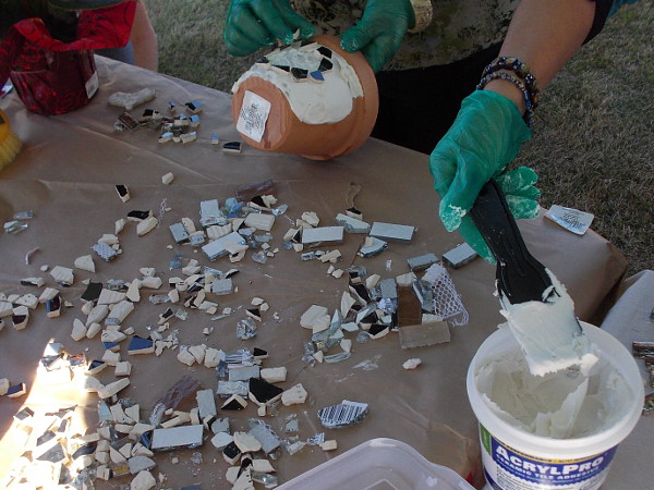 Lots of broken bits of tile are spread out on the table like jigsaw puzzle pieces!