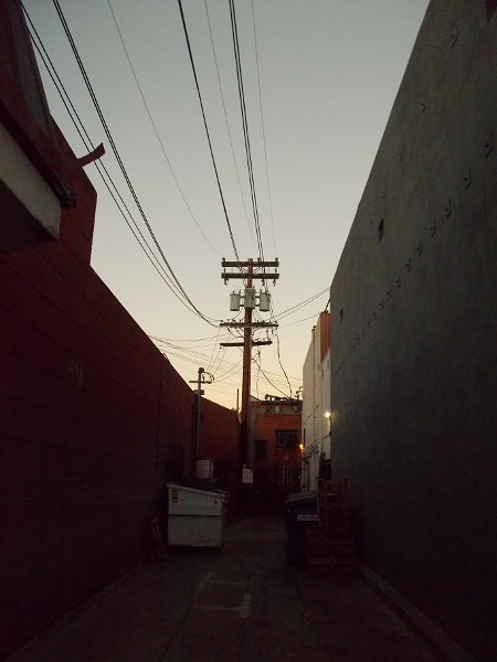 The sky is gradually brightening above a shadowy Hillcrest alley.