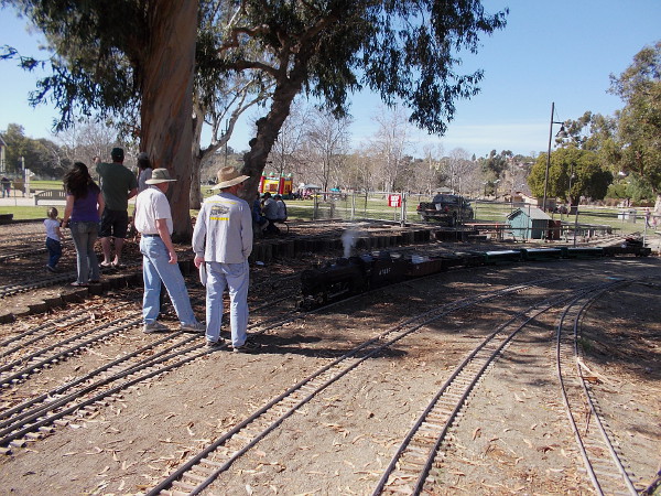 Dedicated train hobbyists have gathered on the surprisingly large rail yard to watch the steam locomotive.
