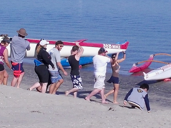 Vacationers watched from the public beach, and the nearby cottages of Paradise Point Resort, as the outrigger canoes were carried to the water.