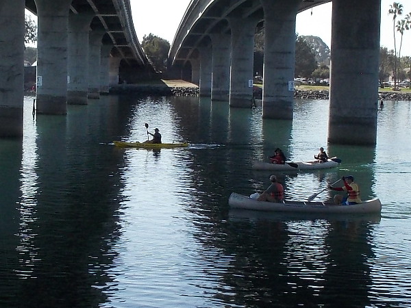 Many canoes and kayaks were passing under the Ingraham Street Bridge between South Cove and Perez Cove, not far from SeaWorld.