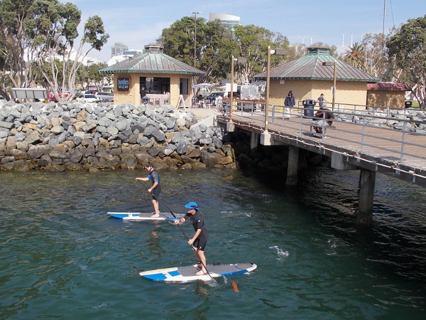 A pair of standup paddleboarders have passed under the Embarcadero Marina Park South Pier, one of my favorite places to visit on San Diego Bay.